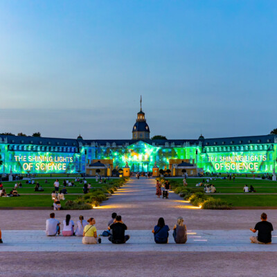Le slogan des JEUX DE LUMIÈRE SANS FIL de Karlsruhe 2025 : "The Shining Lights of Science" (Les lumières brillantes de la science)